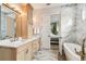 Bright bathroom with double vanity, marble floors, soaking tub, and access to the bedroom at 13711 Lussier Ln, Spring Hill, FL 34610