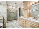 Elegant bathroom featuring marble tile, a glass enclosed shower, and a double sink vanity at 13711 Lussier Ln, Spring Hill, FL 34610