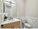 Chic powder room featuring a wood vanity, decorative mirror, and stylish fixtures at 13711 Lussier Ln, Spring Hill, FL 34610