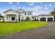 Beautiful two-story white home with manicured lawn and attached three car garage at 13711 Lussier Ln, Spring Hill, FL 34610