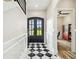 Inviting foyer with black and white tile flooring and a view into the study at 13711 Lussier Ln, Spring Hill, FL 34610
