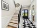 Bright foyer featuring a staircase, black and white tile flooring, and a modern front door at 13711 Lussier Ln, Spring Hill, FL 34610
