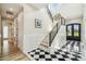 Bright foyer featuring black and white tile flooring, staircase and paneled walls at 13711 Lussier Ln, Spring Hill, FL 34610
