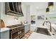 Luxury kitchen showcasing a custom range hood, marble countertops, and stainless steel farmhouse sink at 13711 Lussier Ln, Spring Hill, FL 34610