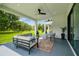Covered patio with modern furniture, ceiling fan, and view of the expansive backyard at 13711 Lussier Ln, Spring Hill, FL 34610