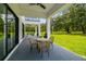 Covered patio with an outdoor dining set, ceiling fan, and view of the landscaped backyard at 13711 Lussier Ln, Spring Hill, FL 34610
