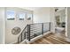 Second floor landing with modern black railing, wood flooring, and natural light from three windows at 13711 Lussier Ln, Spring Hill, FL 34610
