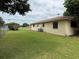 Fenced backyard featuring well-maintained lawn and exterior view of the home's siding and windows at 13742 14Th St, Dade City, FL 33525