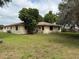 Home exterior showcasing back of house with a large yard and mature trees at 13742 14Th St, Dade City, FL 33525