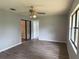 Bedroom with ceiling fan, closet, and wood-look vinyl flooring at 13742 14Th St, Dade City, FL 33525