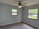 Bedroom featuring neutral carpet, ceiling fan, and view of backyard at 13742 14Th St, Dade City, FL 33525