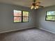 Bedroom with carpeted floor and view of beautiful bougainvillea through the window at 13742 14Th St, Dade City, FL 33525