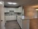 Bright kitchen with white cabinets, light countertops, and a breakfast bar overlooking the living area at 13742 14Th St, Dade City, FL 33525