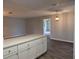 Bright view from the kitchen featuring white breakfast bar, wood-look vinyl floors, and modern paint at 13742 14Th St, Dade City, FL 33525