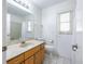 Bathroom with a wood vanity, a marble countertop, a window with curtains, and a toilet at 1426 Buckner Rd, Valrico, FL 33596