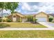 Charming home featuring mature landscaping, a well-manicured lawn, and an attached two-car garage at 1426 Buckner Rd, Valrico, FL 33596