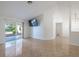 Spacious living room featuring neutral walls, tile flooring, and sliding glass doors to the lanai at 1426 Buckner Rd, Valrico, FL 33596