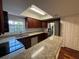 Kitchen featuring stainless steel appliances, granite counters, dark wood cabinets, and a window at 14446 Reuter Strasse Cir # 3, Tampa, FL 33613