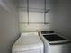 Convenient laundry room with modern washer, dryer, and wire shelving for storage at 14446 Reuter Strasse Cir # 3, Tampa, FL 33613