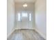 Clean, white entryway with gray tile flooring, white front door, and modern lighting at 16511 66Th E Ln, Parrish, FL 34219