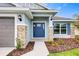 Inviting entryway with a blue front door, stone accents, and manicured landscaping at 16511 66Th E Ln, Parrish, FL 34219