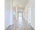 Bright hallway with gray tile flooring leading to a living space and a door at 16511 66Th E Ln, Parrish, FL 34219