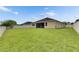 A spacious backyard featuring well-maintained lawn and a white fence with views of the home at 17516 Bright Wheat Dr, Lithia, FL 33547