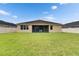 A spacious backyard has lush green grass, views of the home, and a white fence at 17516 Bright Wheat Dr, Lithia, FL 33547