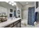 Stylish bathroom features a dark vanity, white countertop, and a shower with a decorative blue curtain at 17516 Bright Wheat Dr, Lithia, FL 33547