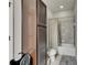 Bathroom boasts a shower with gray tile and a tall, narrow linen closet for storage at 17516 Bright Wheat Dr, Lithia, FL 33547