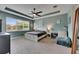 Spacious bedroom featuring a ceiling fan, tray ceiling, and plush gray carpet at 17516 Bright Wheat Dr, Lithia, FL 33547