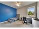 Cozy bedroom features a gray bed frame, blue accent wall, and a functional desk area near the window at 17516 Bright Wheat Dr, Lithia, FL 33547