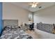 Comfortable bedroom with a gray bed, dresser, and desk near the window, offering a relaxing space at 17516 Bright Wheat Dr, Lithia, FL 33547