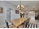 Dining room leading to a kitchen with a wooden table and chandelier lighting fixture at 17516 Bright Wheat Dr, Lithia, FL 33547