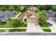 Aerial view of a single-story home with a well-manicured lawn, mature landscaping, and a 3-car garage at 17516 Bright Wheat Dr, Lithia, FL 33547