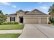 Inviting single-story home with a well-manicured lawn, a two-car garage, and neutral-toned exterior paint at 17516 Bright Wheat Dr, Lithia, FL 33547