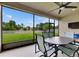 The covered lanai has a ceiling fan, table, chairs, and a view of a fenced-in backyard at 17516 Bright Wheat Dr, Lithia, FL 33547