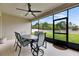 View of covered lanai with ceiling fan, table, and chairs overlooking a fenced-in backyard at 17516 Bright Wheat Dr, Lithia, FL 33547
