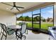Covered lanai offers a ceiling fan, table, and chairs looking out to a fenced-in backyard at 17516 Bright Wheat Dr, Lithia, FL 33547