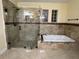 Modern bathroom featuring glass enclosed shower and tub, with tile and granite accents at 18104 Sweet Jasmine Dr, Tampa, FL 33647