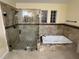 The bathroom features a glass shower and tub with neutral tile and modern fixtures at 18104 Sweet Jasmine Dr, Tampa, FL 33647