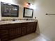 Dual sink bathroom features granite countertops and dark wood cabinetry at 18104 Sweet Jasmine Dr, Tampa, FL 33647