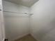 An interior closet with neutral walls and a bar for hanging clothes at 18104 Sweet Jasmine Dr, Tampa, FL 33647