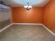 This spacious living room boasts tile floors, neutral walls, and elegant light fixture; perfect for gatherings at 18104 Sweet Jasmine Dr, Tampa, FL 33647