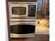 Close-up of stainless steel built-in oven and microwave appliances with custom cabinets at 18104 Sweet Jasmine Dr, Tampa, FL 33647