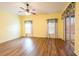 Well-lit bedroom featuring wood floors, two windows, and sliding glass door access to a patio at 19025 Callaway Ct, Tampa, FL 33647