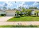 Charming single-story home with a two car garage, lush green lawn, and verdant landscaping at 19025 Callaway Ct, Tampa, FL 33647