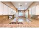 Well-lit kitchen showcases granite counters, white cabinets and a view of breakfast nook at 19025 Callaway Ct, Tampa, FL 33647