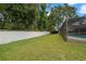 A spacious backyard featuring lush green grass and a tall white fence, perfect for outdoor activities at 1951 Downing Pl, Palm Harbor, FL 34683