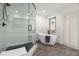 Modern bathroom with glass shower, soaking tub, and stained glass window for character at 1951 Downing Pl, Palm Harbor, FL 34683